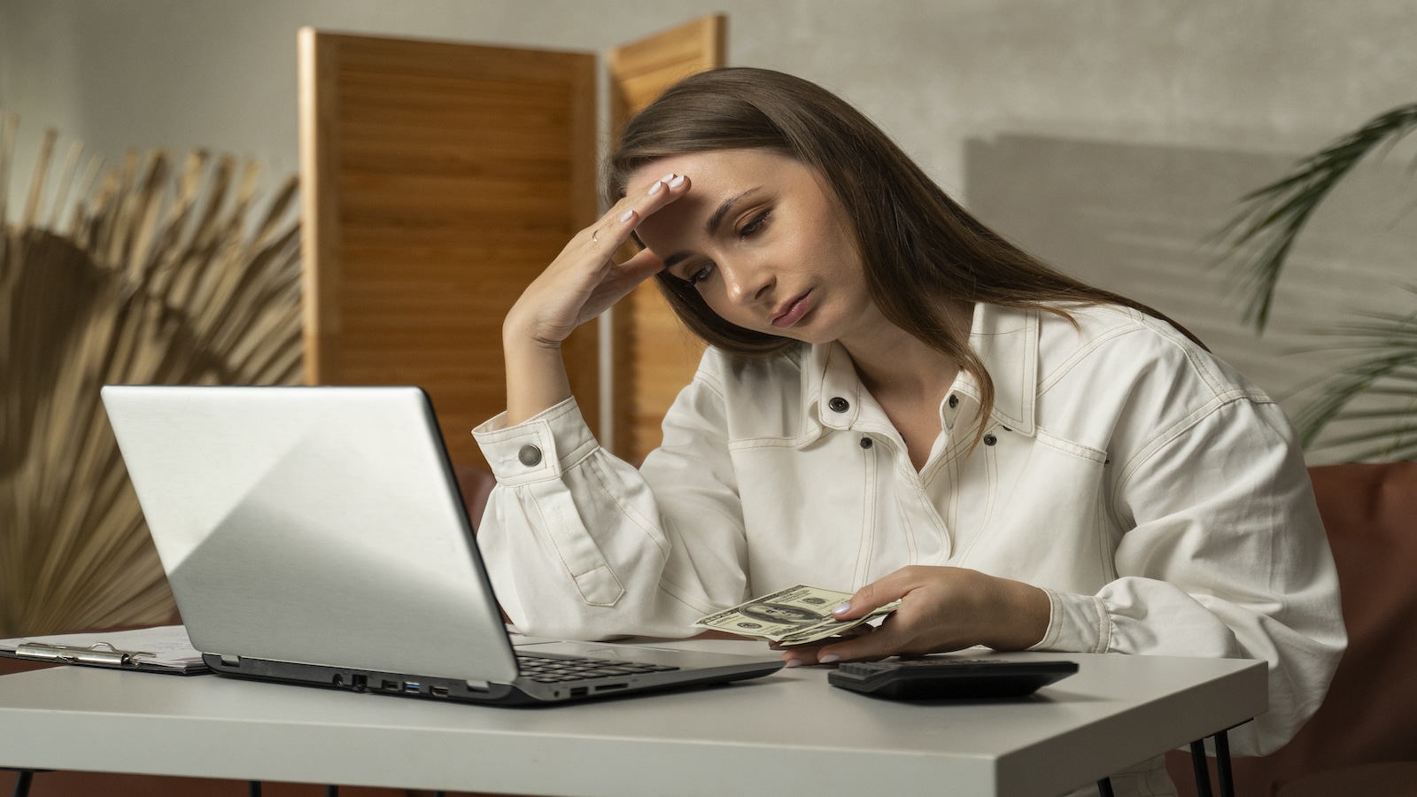 woman stressed looking at computer and bills.