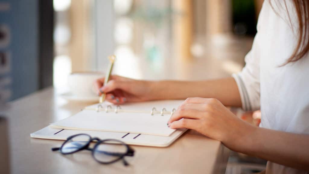 woman writing in planner.