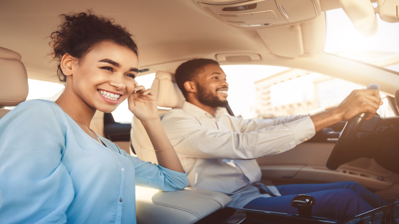 young couple smiling and driving.