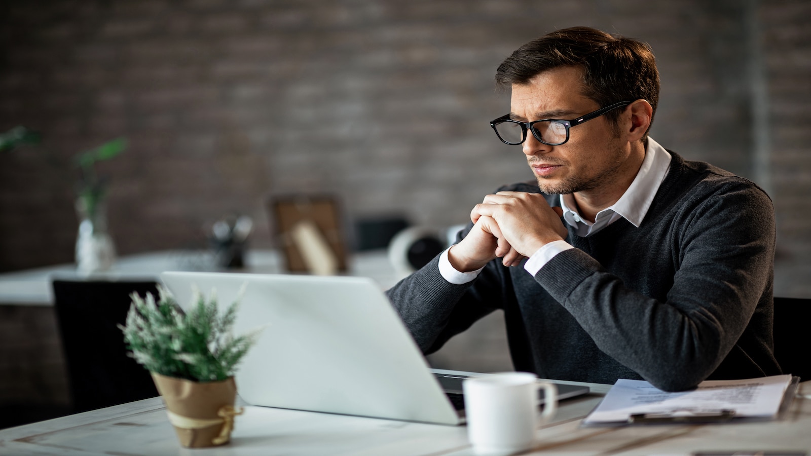 Businessman typing while using laptop and working in the office.