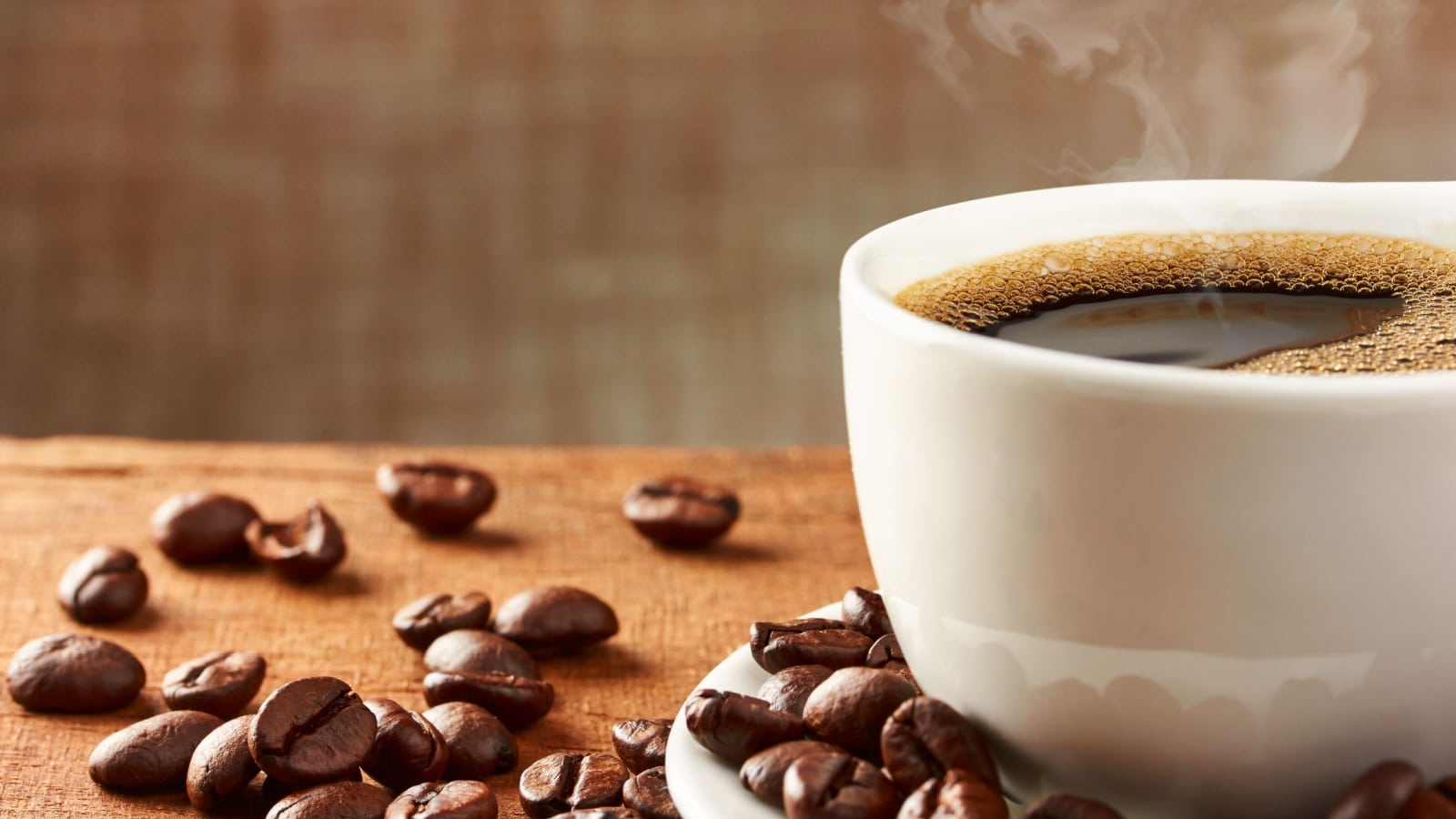 Coffee cup and coffee beans on table.