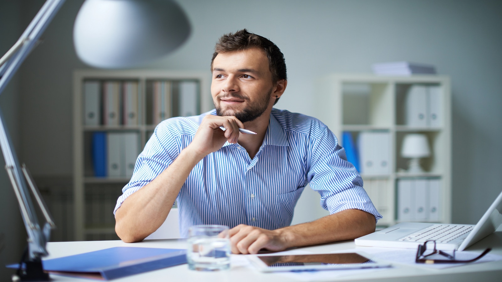 Smart businessman thinking about something in office computer on desk.