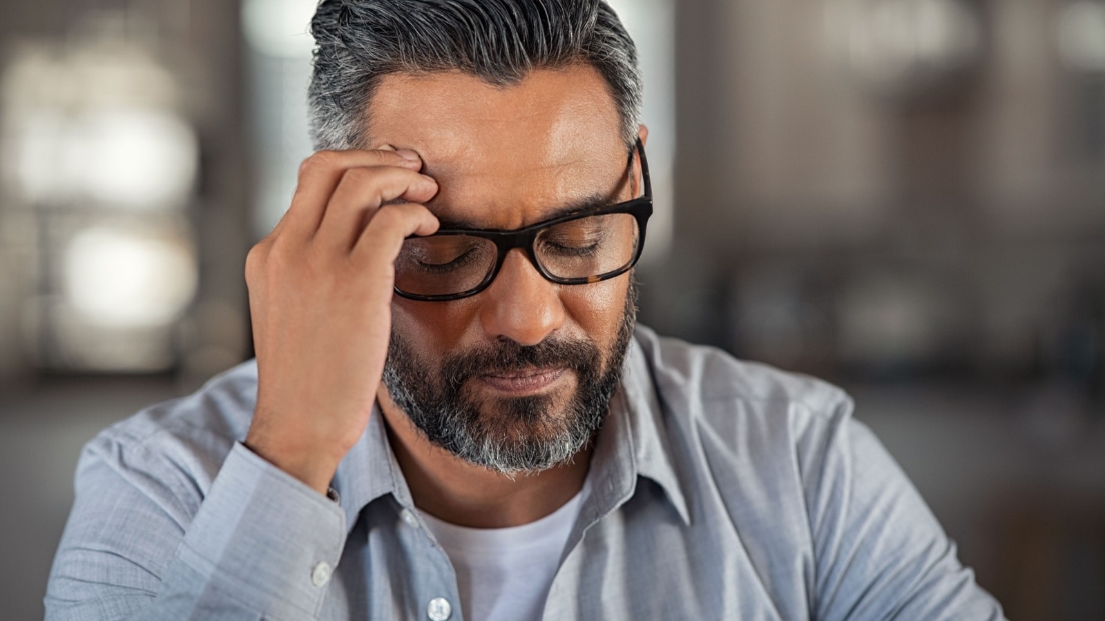 Frustrated man sitting on couch at home.