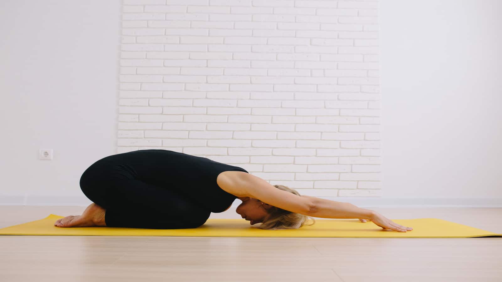 Woman doing childs pose in yoga class