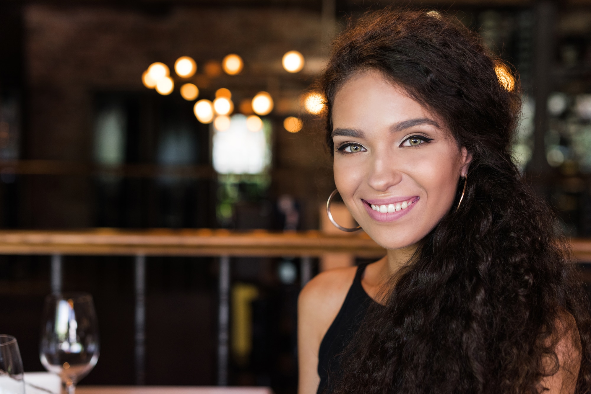 Beautiful young woman in restaurant smiling close-up