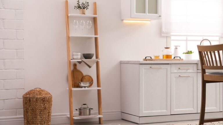 Stylish kitchen room interior with wooden ladder near white wall