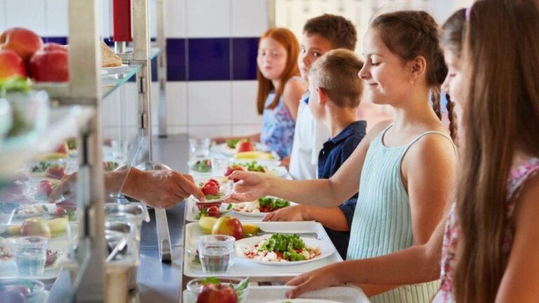 Group of children as elementary students at buffet line, enjoying variety of food options