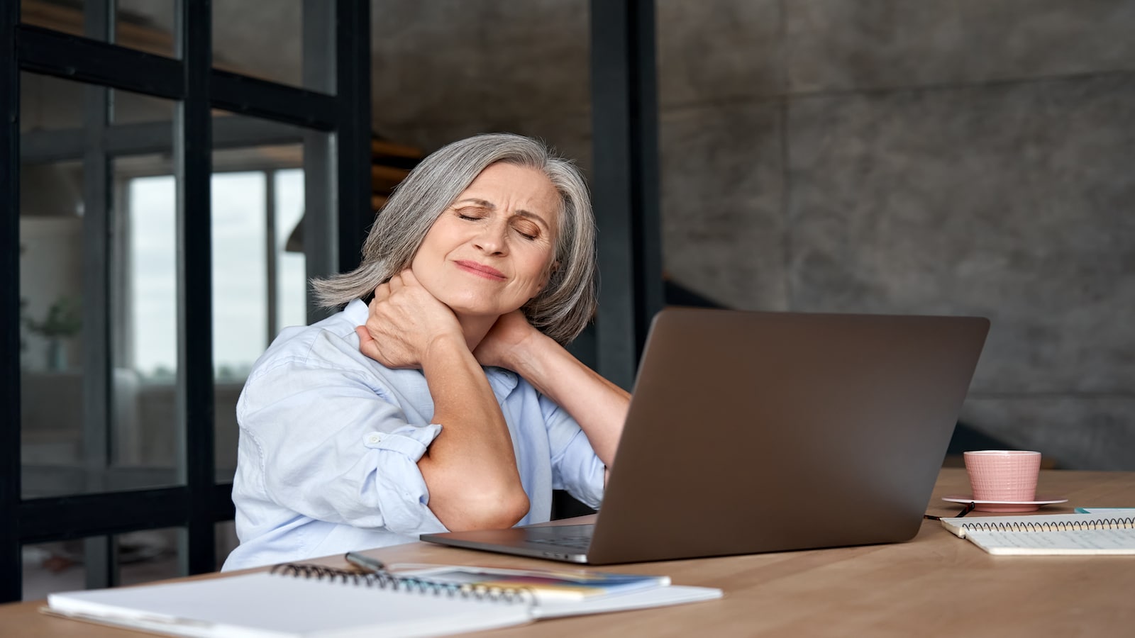 Tired older mature woman neck hurts overworked pain sedentary job.