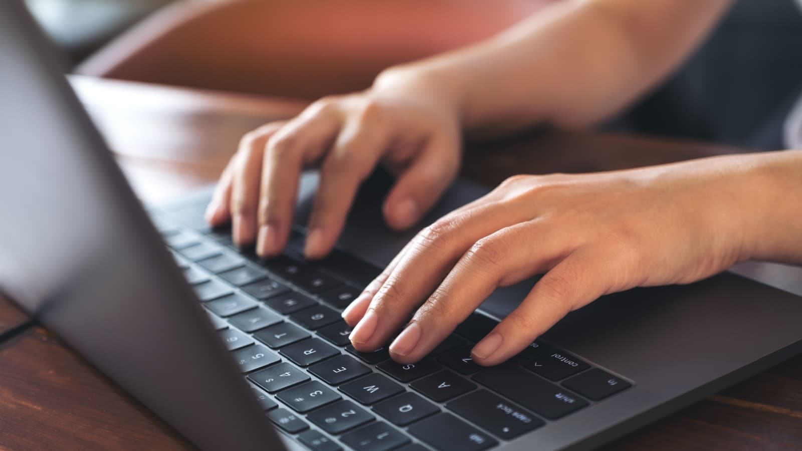 Closeup image of a business woman's hands working and typing on laptop keyboard.