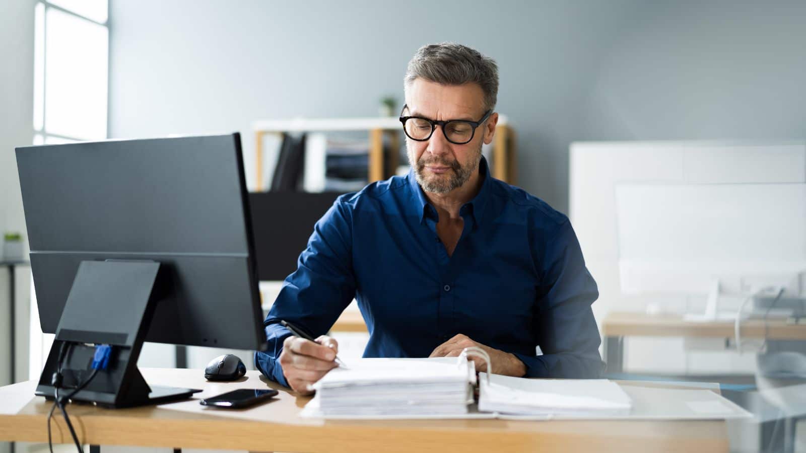 Man looking through documents and making notes.