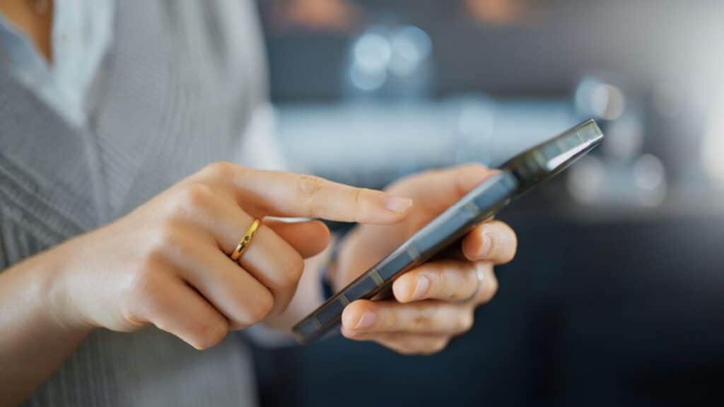 Smartphone, marketing and business hand contact information, website application or reading target advertising. Typing, scroll and social media network worker using phone or cellphone in bokeh zoom.