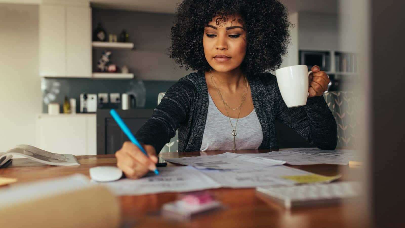 Woman making a plan at home with a cup of coffee.