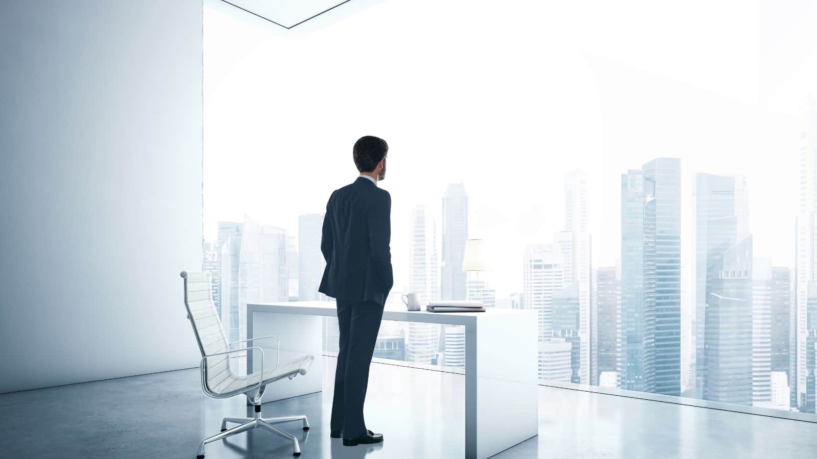 Young man looking through the office's window.