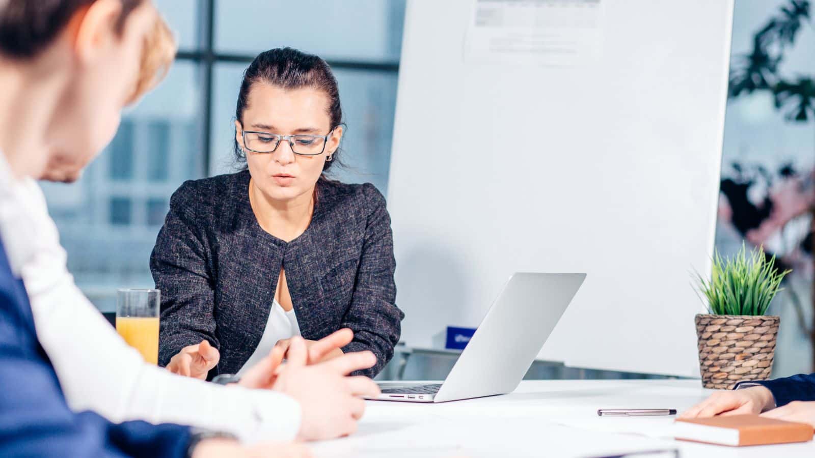 Young woman looking at some files on the desk in a meeting at the office.