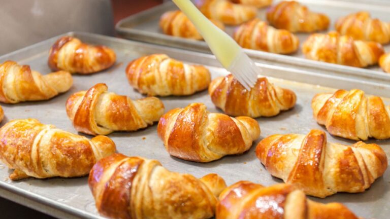 Professional bakery. Detail of Hands preparing french croissant in color
