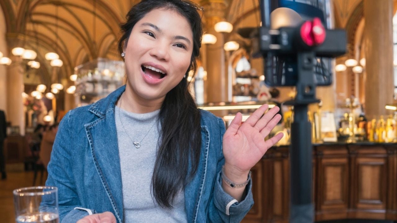 Asia travel vlogger introduce great menu famous restaurant while lives streaming for social reel video social media platform,Social media influencer online video of food at cafe, smartphone