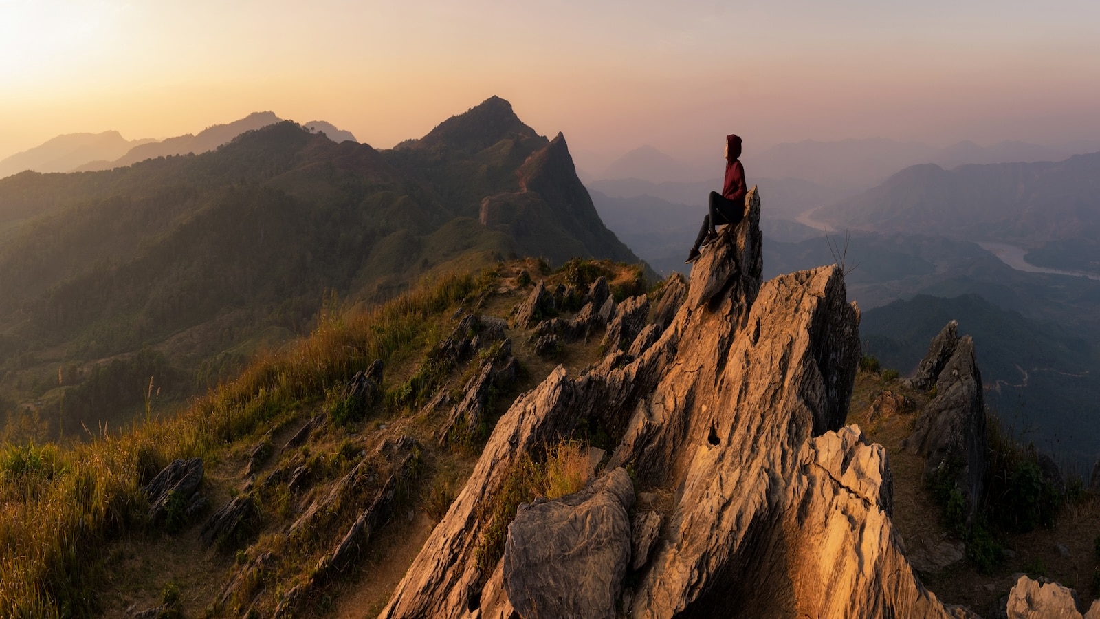 Person sitting on mountain top.