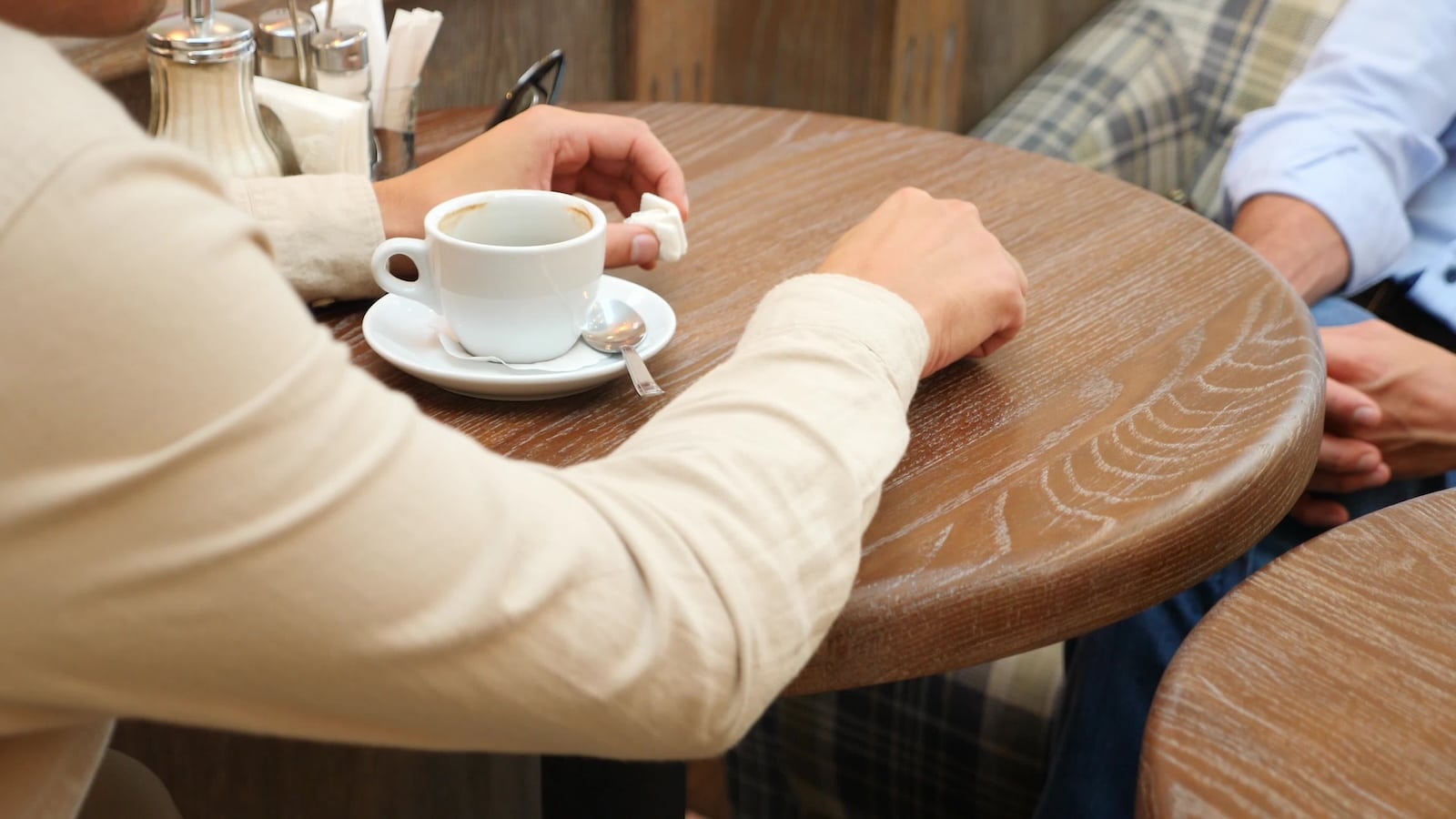 Couple having coffee in cafe woman hand knocking on table.