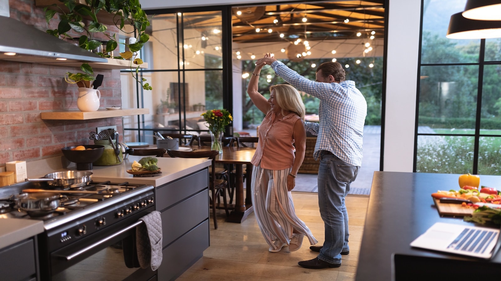 Mature older couple dancing in kitchen.