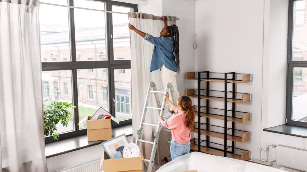 home improvement woman putting up curtains standing on ladder.