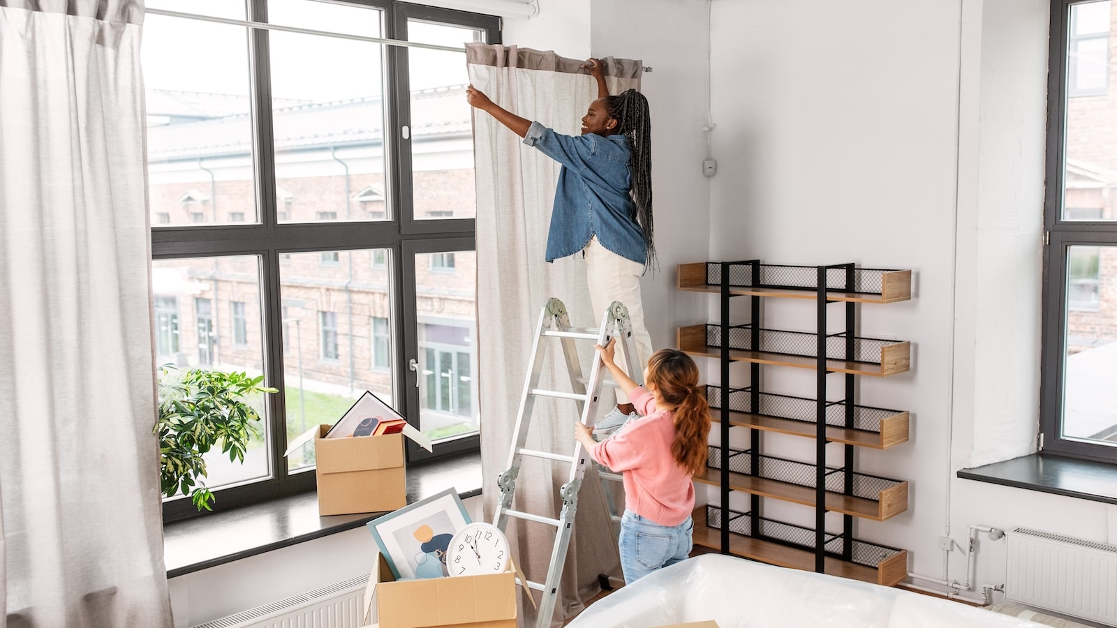 home improvement woman putting up curtains standing on ladder.