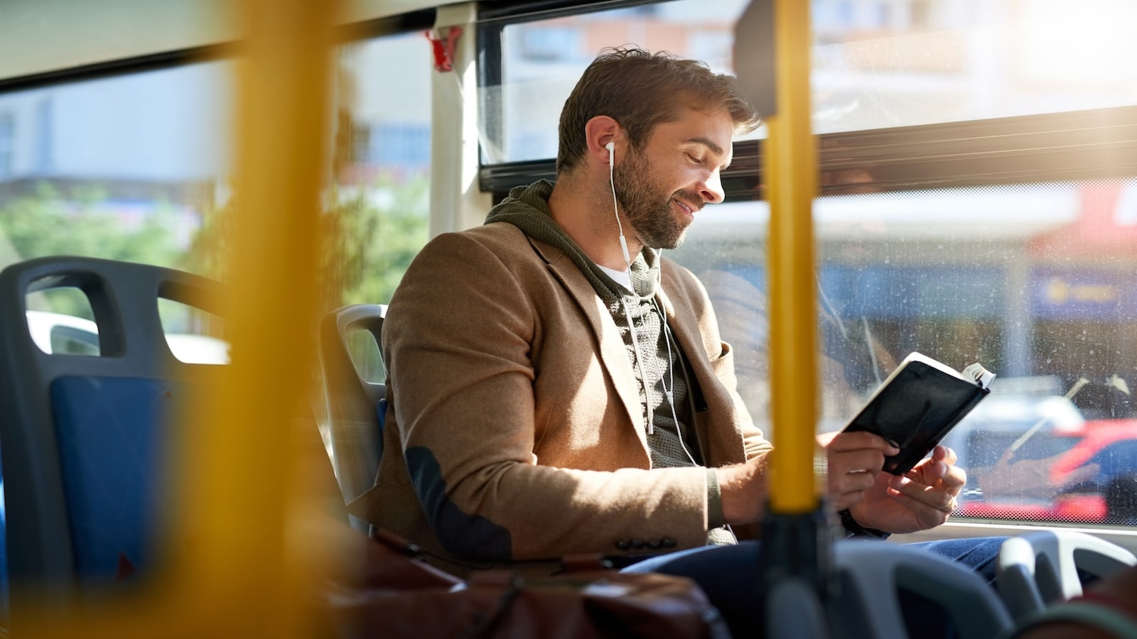 Man reading book on bus.