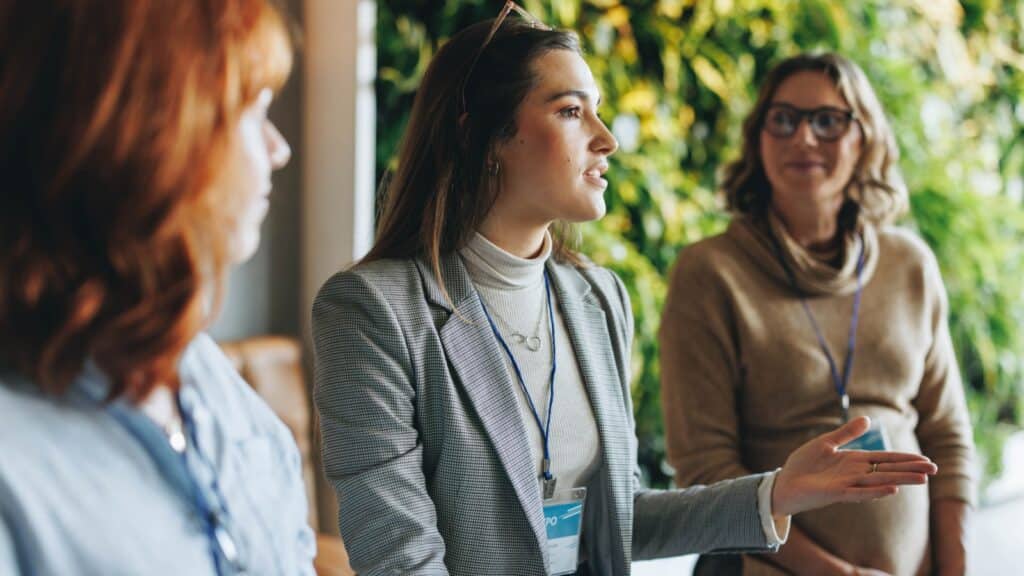 Group of business women engaged in a productive discussion. Colleagues working in a professional environment, part of a panel conference. The focus is on effective communication and networking skills.