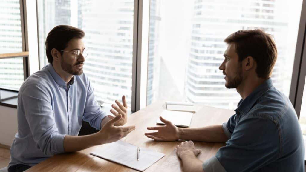 Young man having a talk with his colleague at the office.