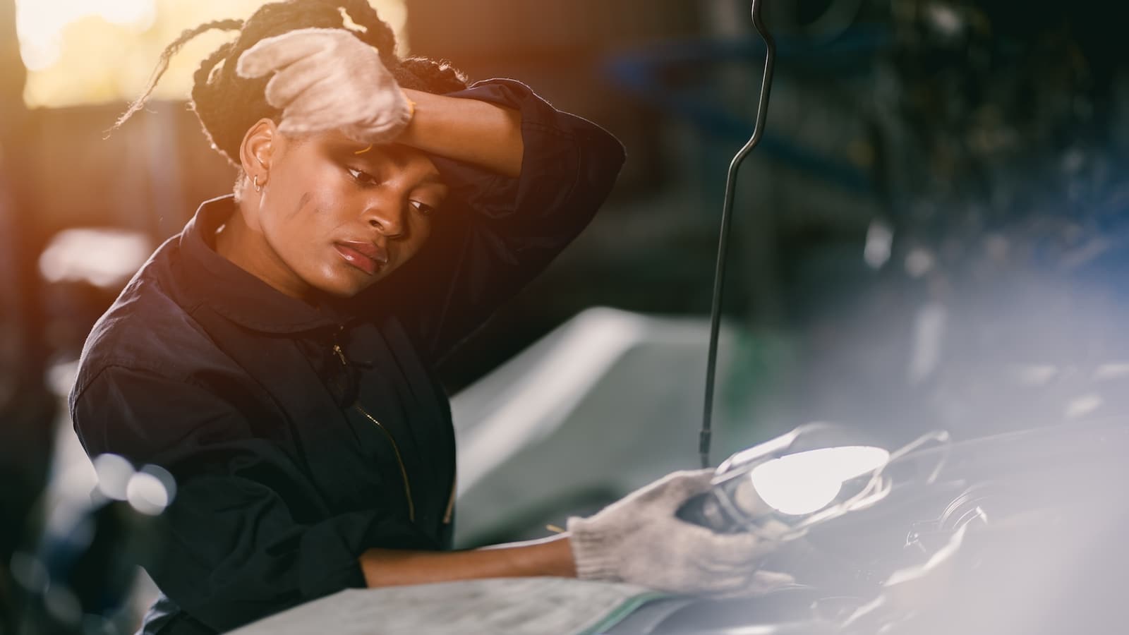 Woman working hard as a mechanic on an engine.