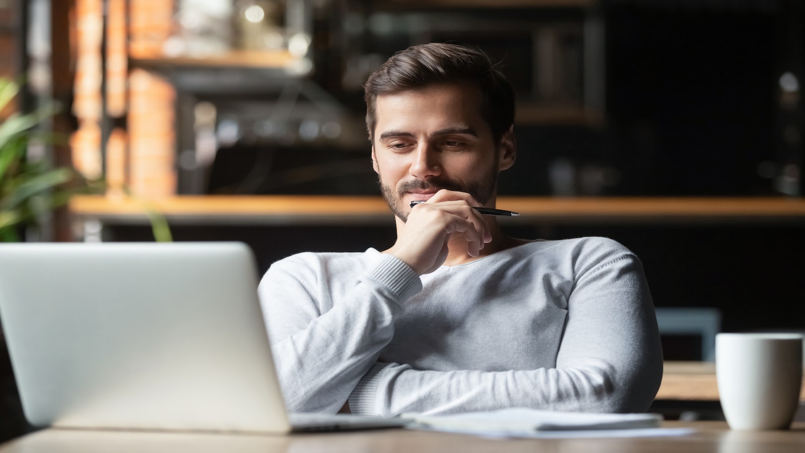 Man sitting at computer thinking.