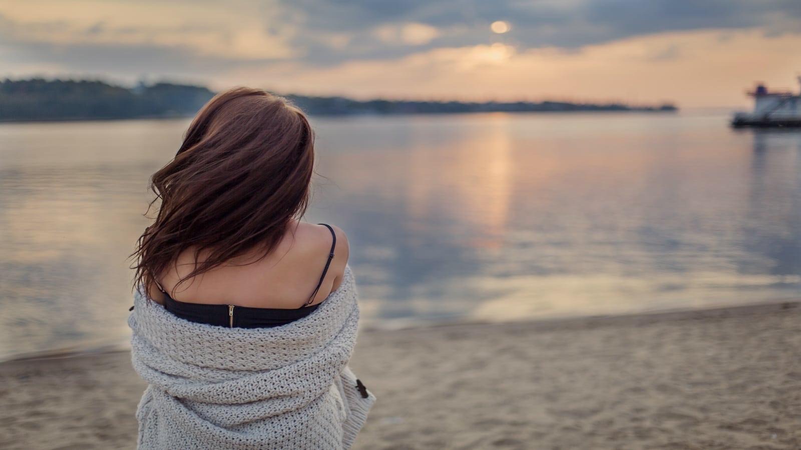Woman watching sunset on water lake.
