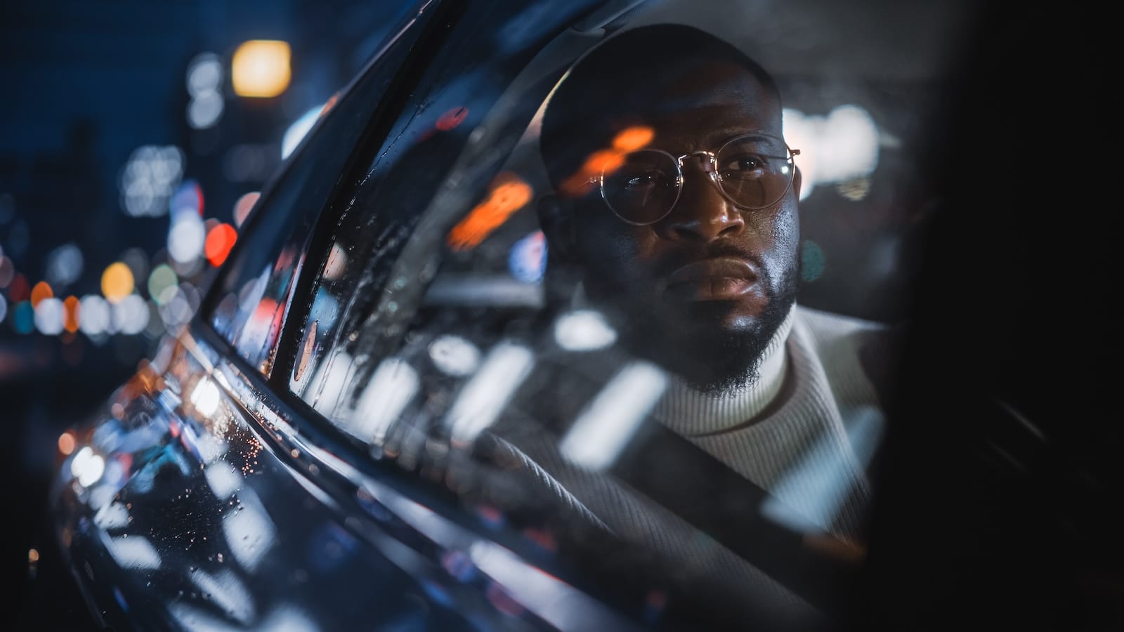 Man riding in car looking out window thinking.