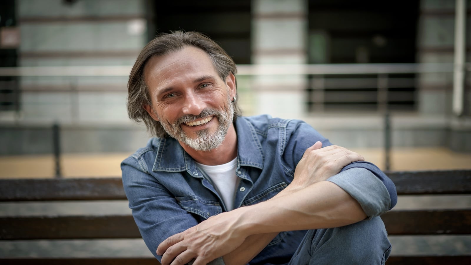 Man smiling happy sitting on bench.
