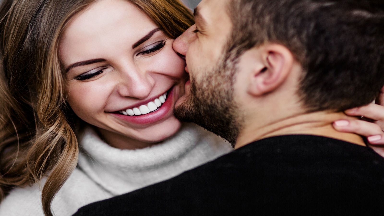 Young couple in love hug each other on the black background.