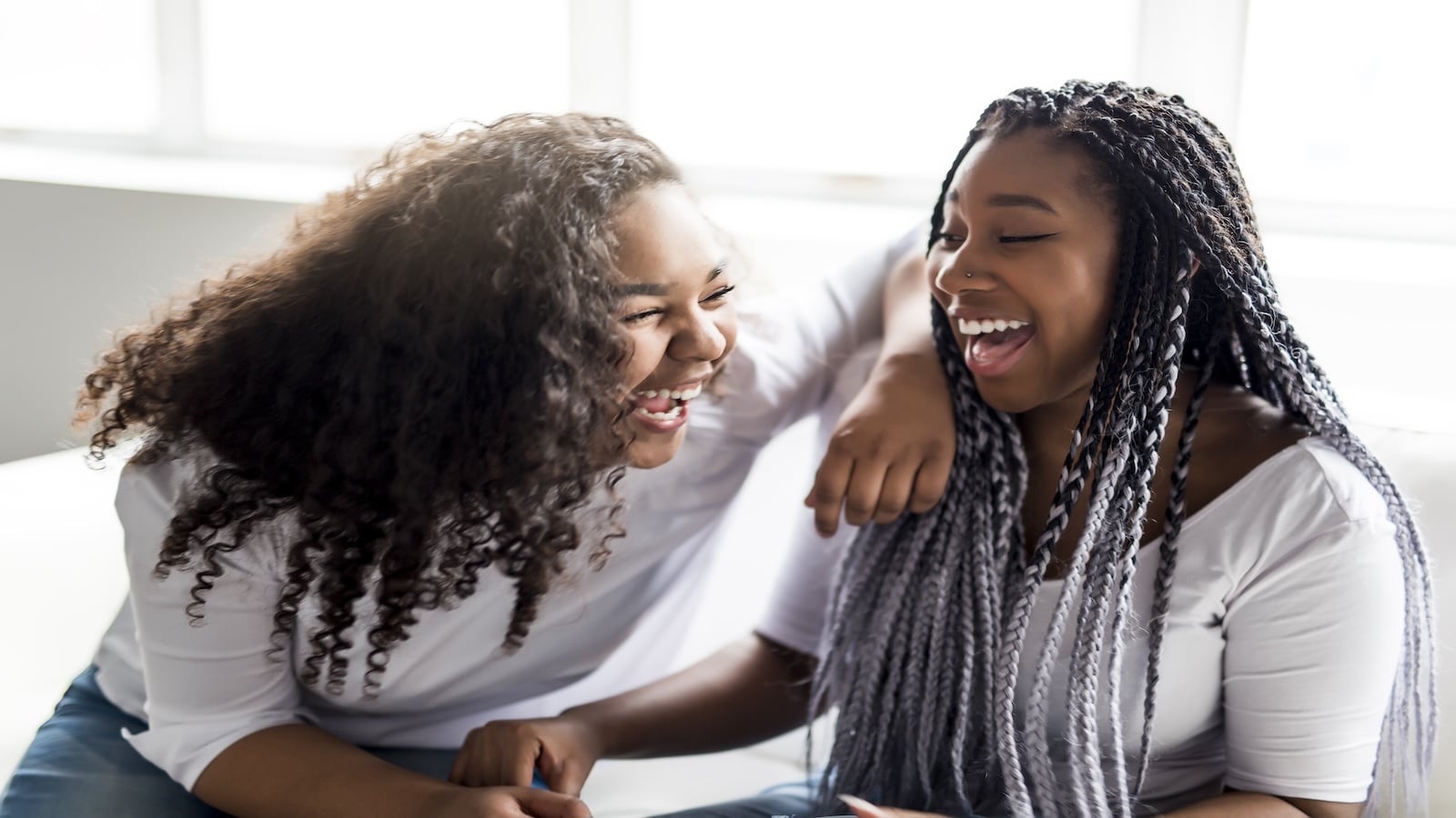 Two affectionate friends afro american sitting on sofa.