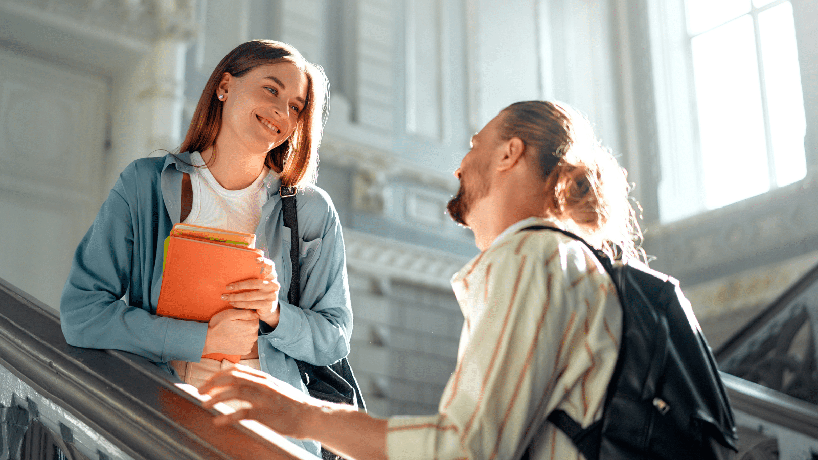 A friend giving a friend a compliment standing on a staircase.