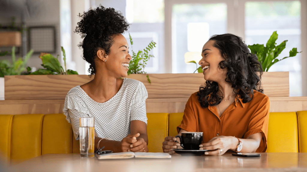 Friends laughing and enjoying coffee.