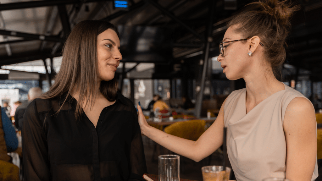 Two women having a conversation in a resturant.