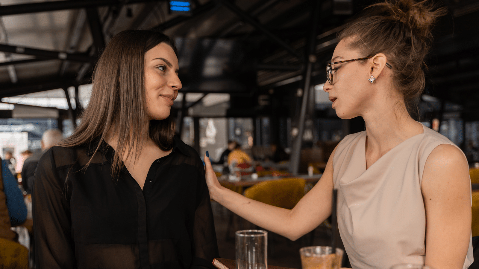 Two women having a conversation in a resturant.