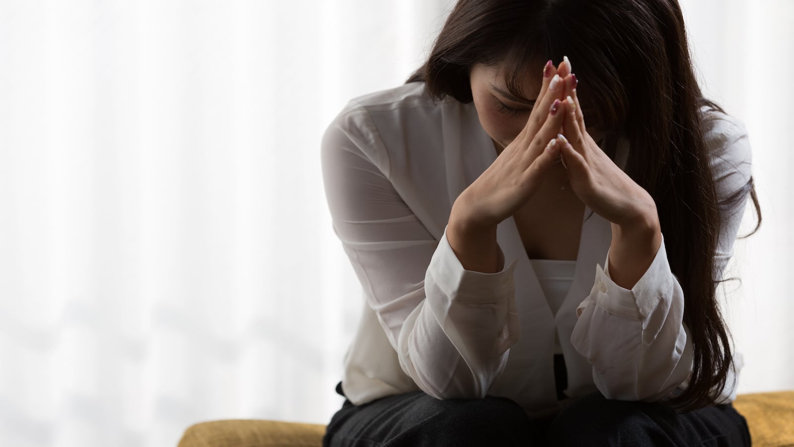 A woman holding her head wondering why is life unfair.