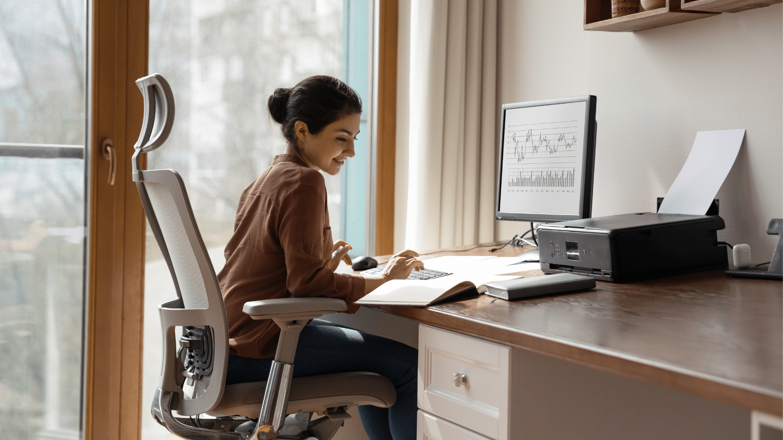Woman working in a comfortable adjustable ergonomic armchair with lumbar support.