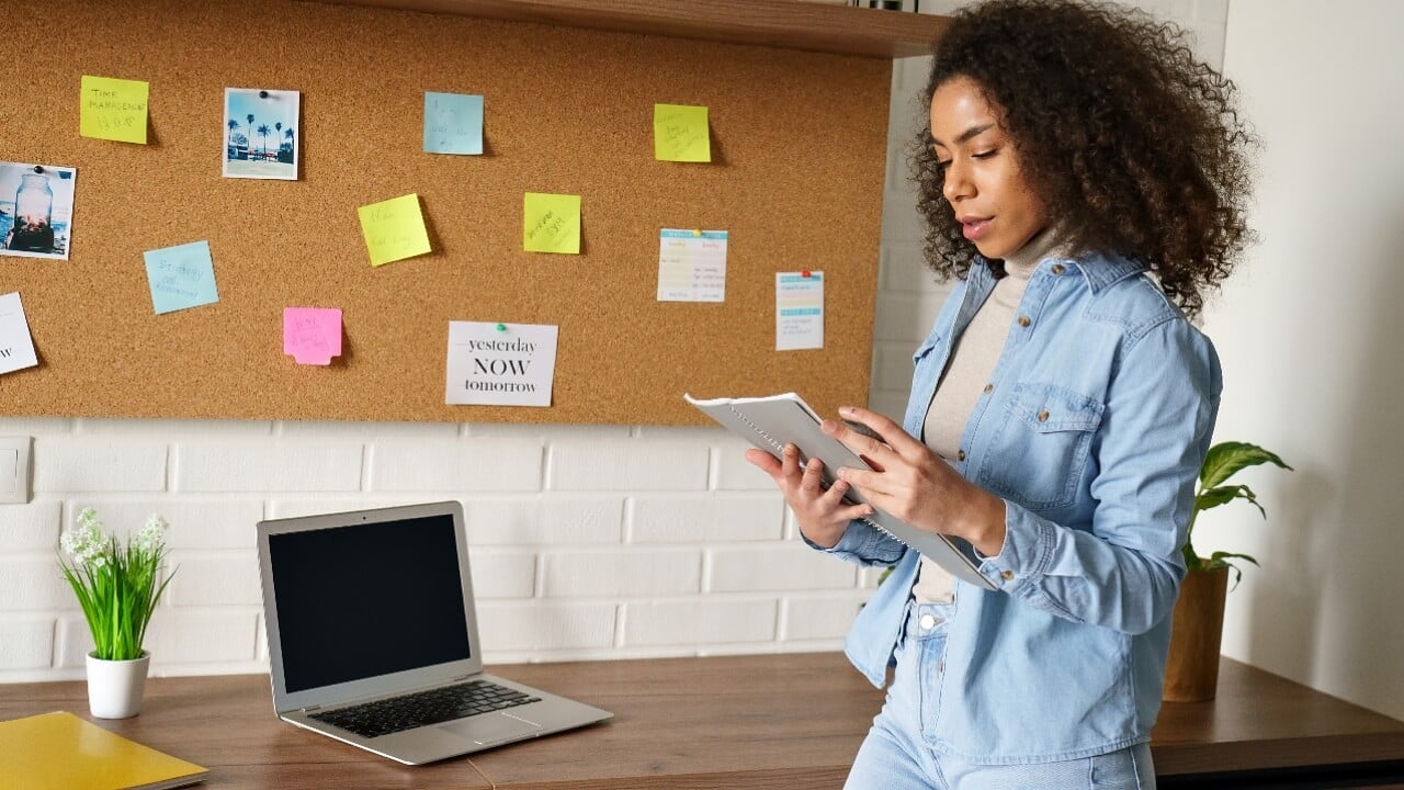 Woman with sticky notes on cork board, goals, plans, future