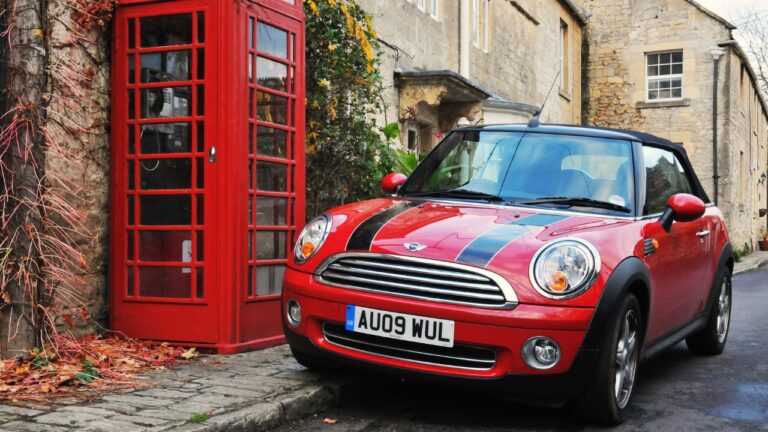 Featured image on 7/19/24. Stock Photo ID: 250675984. View of a Mini Cooper car and traditional red phone box on a village street on Nov6, 2010 in Turleigh, UK. The mini and red phone boxes are uniquely British design icons.