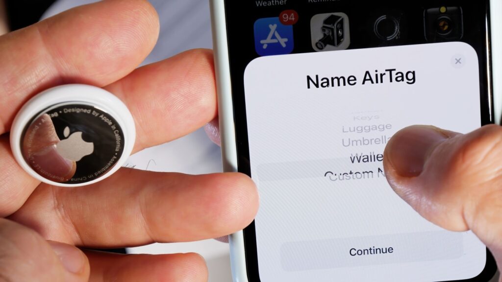Paris, France - May 2, 2021: Name AirTag after unboxing in iPhone app for keys headphones handbag jacket luggage umbrella wallet small device helps people keep track of belongings wallet.