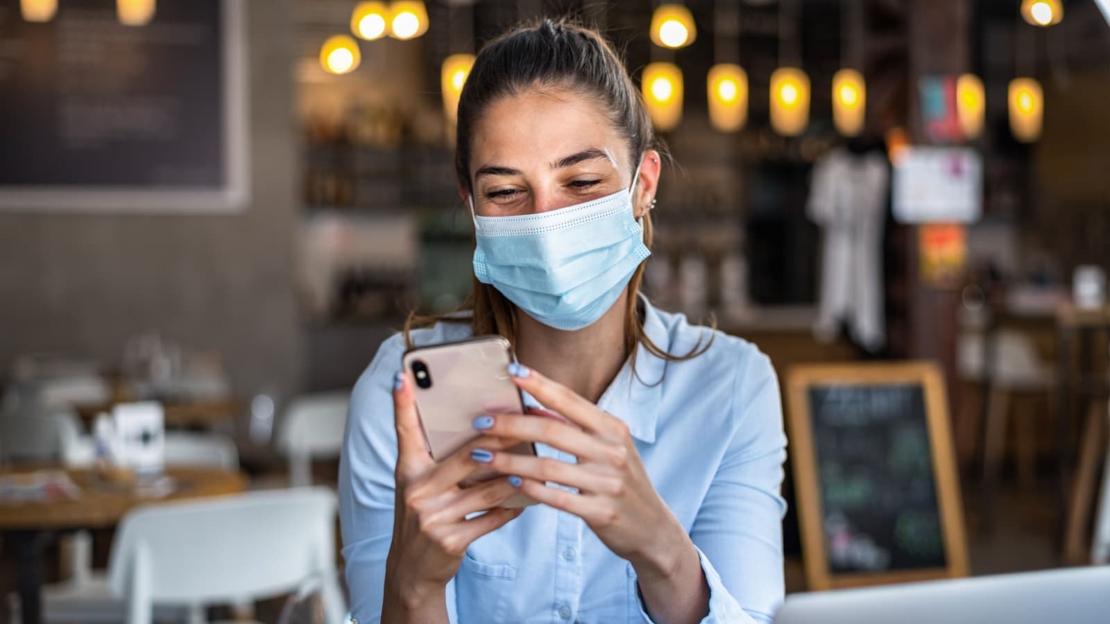 Portrait of a young business woman, wearing mask while talking on a mobile phone. Conceptual of new normal lifestyle during covid-19 pandemic.