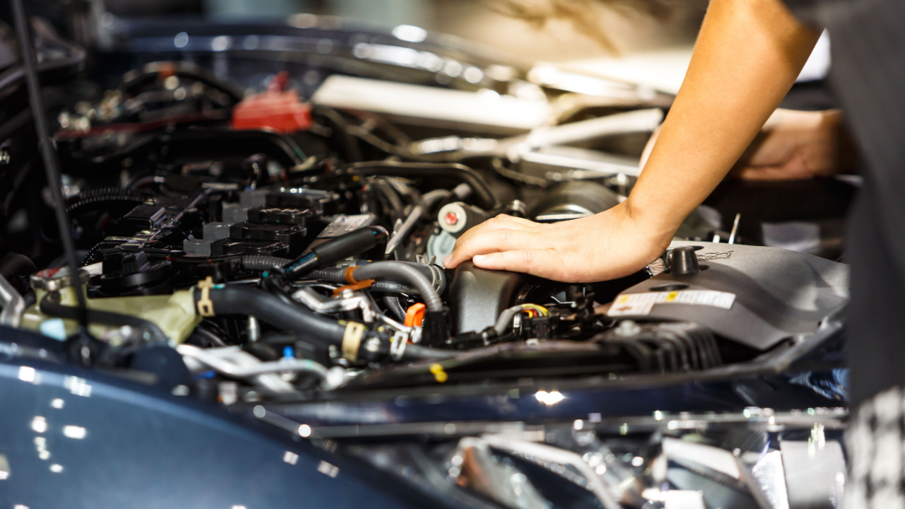 car mechanic's hand in engine bay