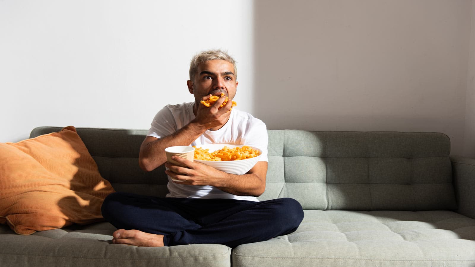 man eating junk food on couch