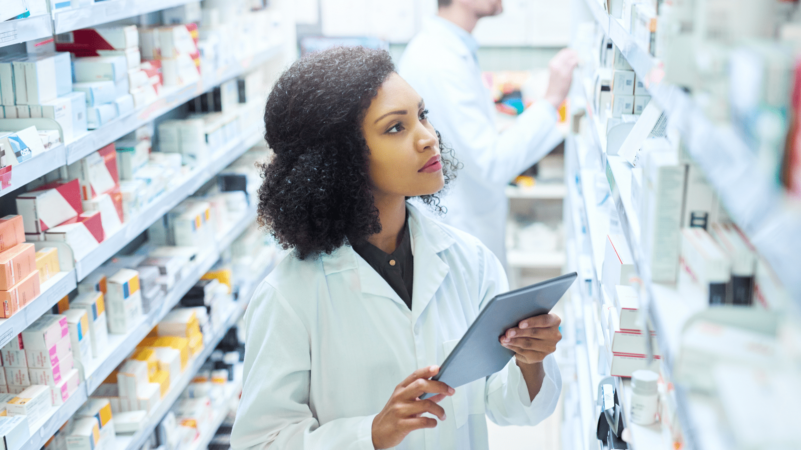 Young woman using a digital tablet to do inventory in a pharmacy.
