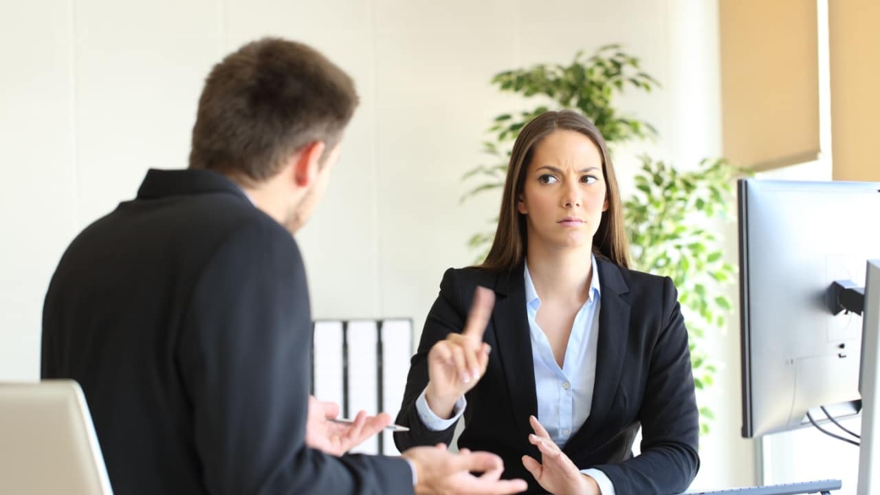 Boss denying something saying no with a finger gesture to an upset employee in her office, interview, angry,
