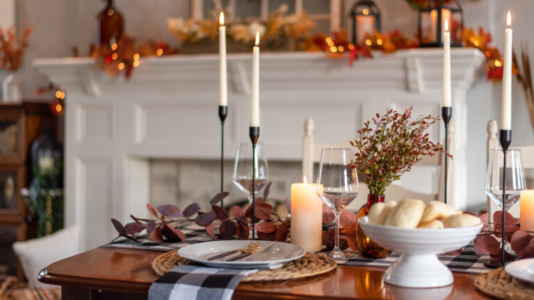 Dinner table decorated for cozy fall holiday gathering
